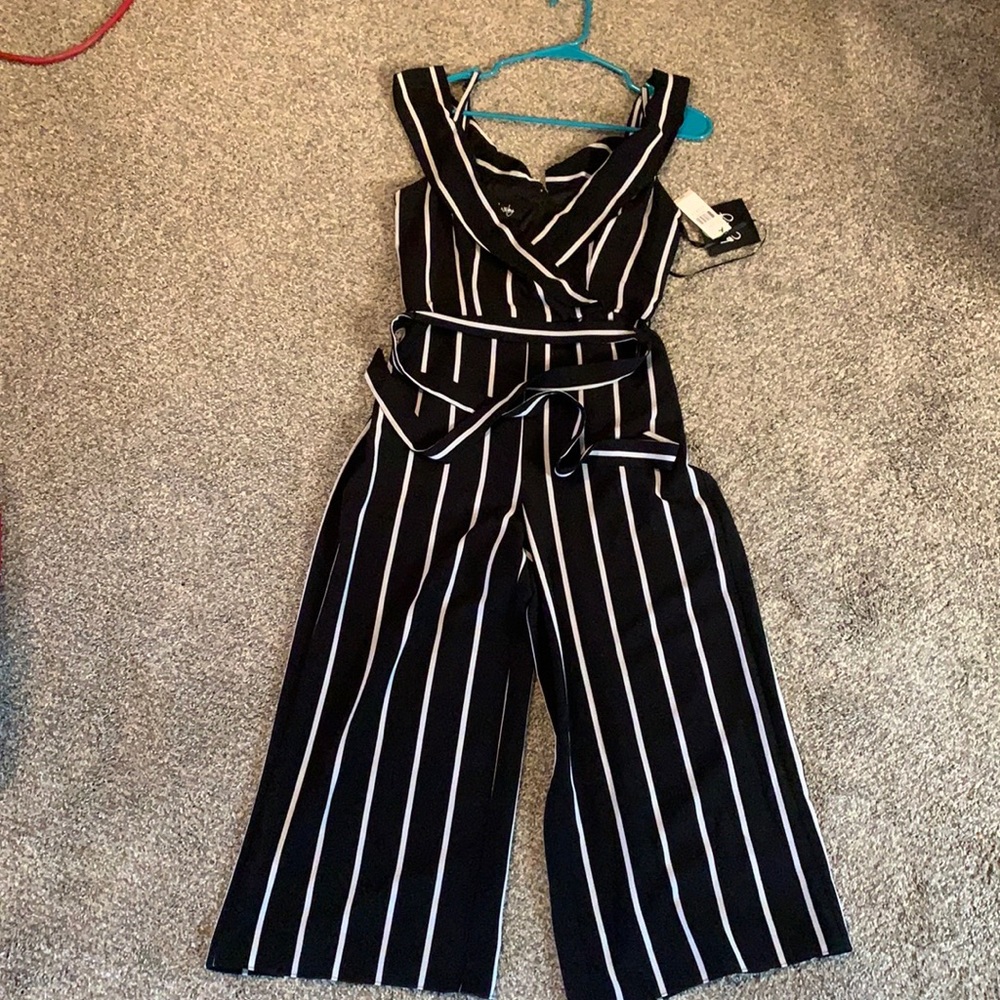 Off the shoulder sleeves with spaghetti straps. Black jumper with white strips